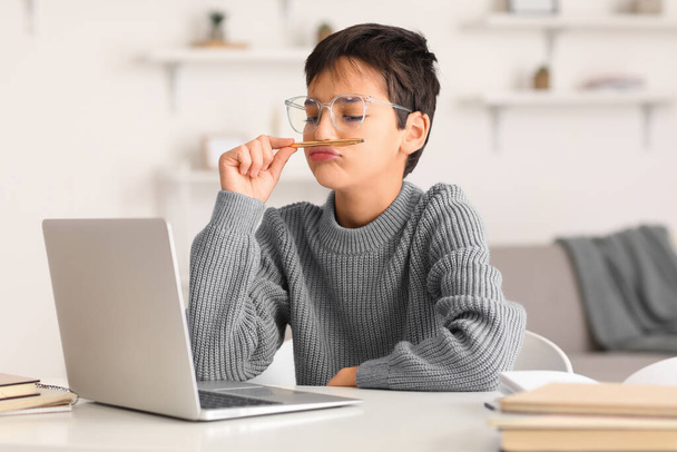 Unatkozó kisfiú tollal használja laptop otthon - Fotó, kép