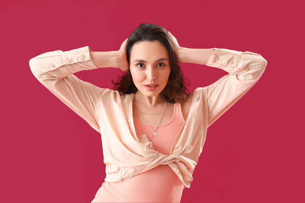 Atraktivní mladá žena v košili na růžovém pozadí - Fotografie, Obrázek