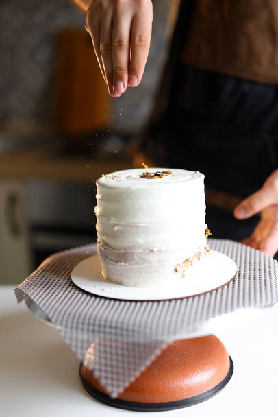 confectioner prepares a cake, ingredients, cake preparation, step-by-step process, decorates a cake with sparkles, cake decoration. High quality photo - Zdjęcie, obraz