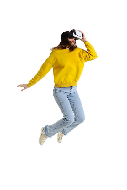 Jumping young woman in VR glasses isolated on white background - Fotografie, Obrázek