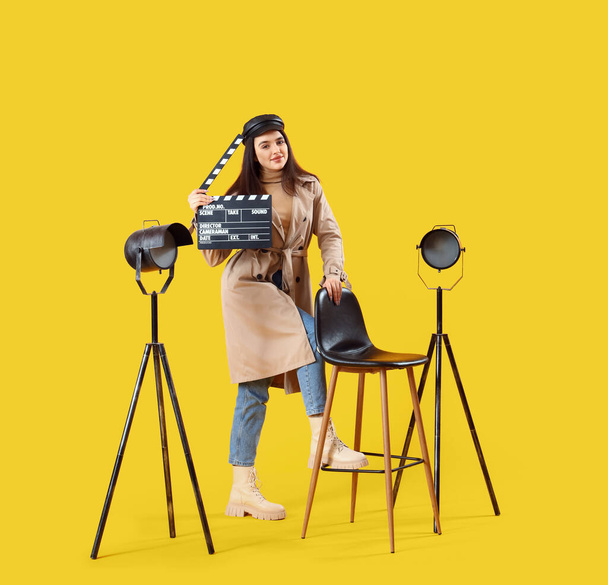 Γυναικείος σκηνοθέτης με ταινία σε κίτρινο φόντο - Φωτογραφία, εικόνα