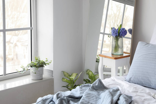 Vaso con fiori di giacinto sul tavolo vicino specchio in camera da letto luce - Foto, immagini