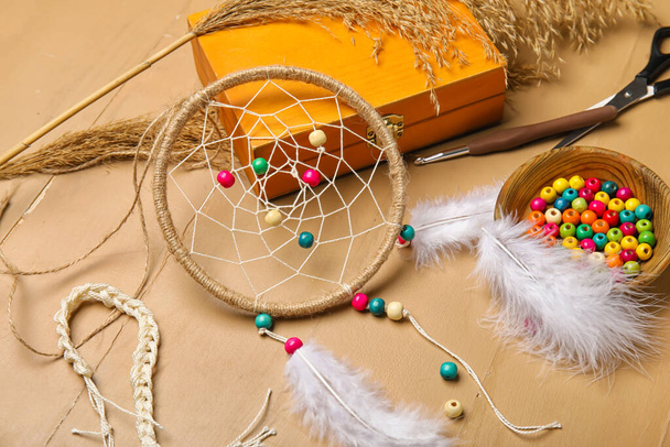 Materials for making dream catcher on beige wooden background, closeup - Фото, изображение