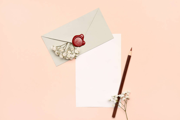 Состав с пустой карточкой, конверт, карандаш и цветы гипсофилы на цветном фоне - Фото, изображение