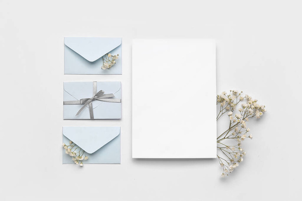Composition with blank card, envelopes and gypsophila flowers on white background - Foto, Imagen