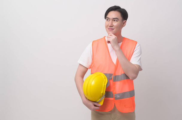 Portrait of male engineer wearing a protective helmet over white background studio. - Foto, imagen