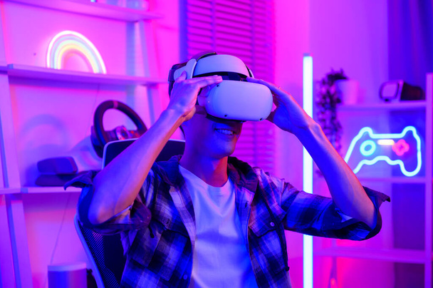 Young Caucasian man Pro Gamer have live streaming  playing video game,  using virtual reality glasses at home - Foto, afbeelding