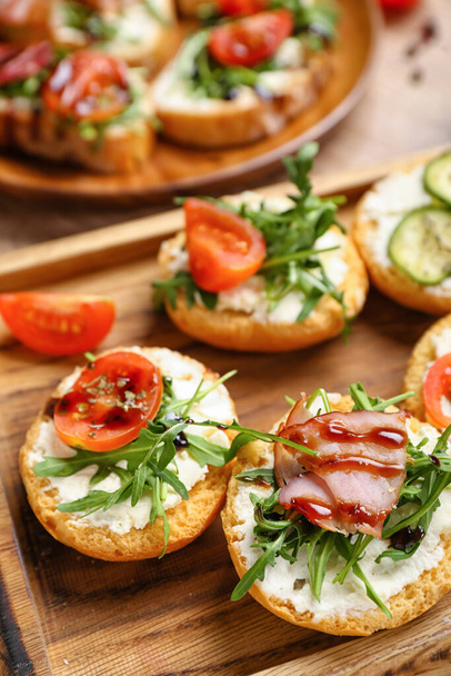 Placa de madeira com sanduíches saborosos, close-up - Foto, Imagem