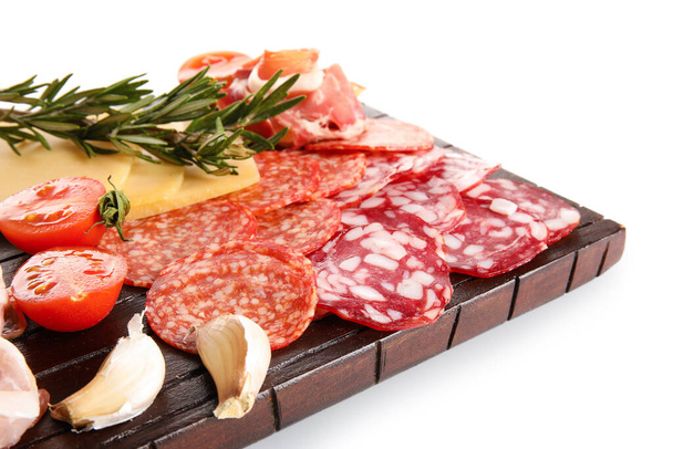 Drewniana deska z asortymentem smacznych mięs delikatesowych izolowanych na białym tle, zbliżenie - Zdjęcie, obraz