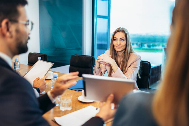 Group of businesspeople having a briefing in a boardroom. Businesspeople working together in a modern workplace. - Photo, Image