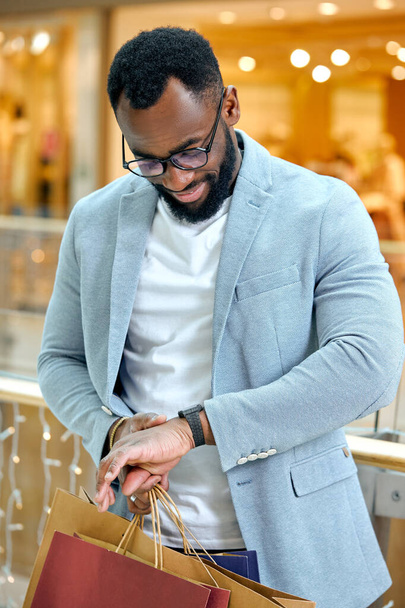 cheerful happy smiling male shopaholic looking at watch on hand, checking delivery time. Late delivery.man waiting for global sales. black friday, - Photo, Image