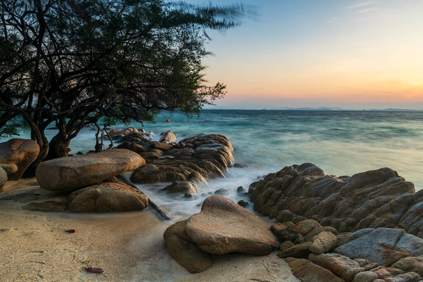 Motion wave seascape through stone arch on beach at sunrise in Ko Man Klang, Rayong, Tailândia. Famoso destino de viagem e férias de verão em país tropical, Sião. - Fotografia, imagem