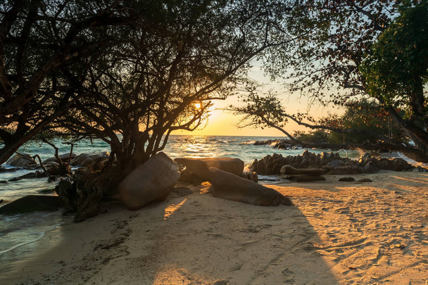 タイ、ラヨーンのKo Man Klangのビーチで石のアーチとマングローブの木を通して日の出。熱帯の国、サイアムでの有名な旅行先と夏の休暇. - 写真・画像