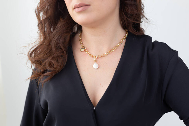 Close up attractive female model cross silver necklace. Woman wearing jewellery. Jewellery photo for e commerce and online sale social media concept - 写真・画像