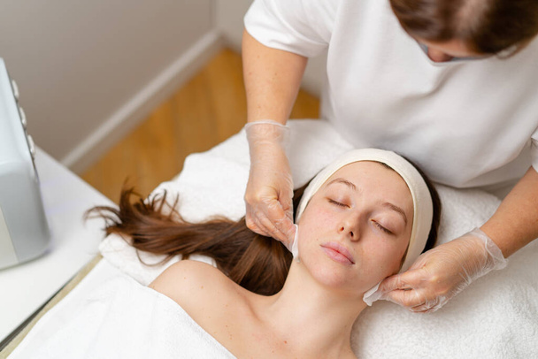 kozmetikai eljárás az arc bőrének fiatalítására kozmetikai klinika orvosánál kozmetikai eljárást végez - Fotó, kép
