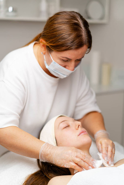 косметическая процедура для омоложения кожи лица пациента в косметологической клинике - Фото, изображение