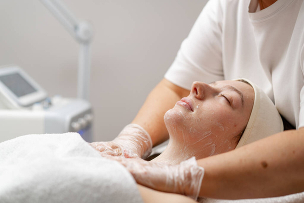 procedimiento cosmético para rejuvenecer la piel del paciente de la cara en una clínica de cosmetología médico hace procedimiento de belleza - Foto, imagen