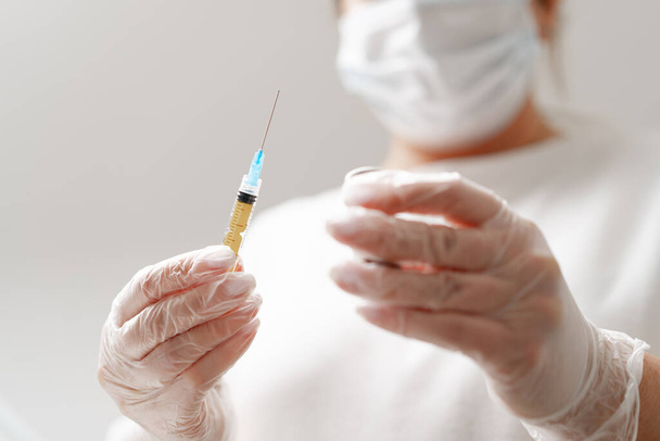 Mãos de médico fêmea seringa de mão segura para injeção no consultório médico de fundo Vacinação de conceito Injeções de cosmetologia - Foto, Imagem