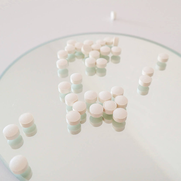 White pills on a mirror background. Health, medicine. Healthcare. High quality photo - Photo, image