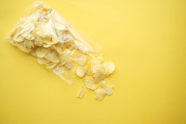 potato chips spilling form a packet on table , - Fotografie, Obrázek
