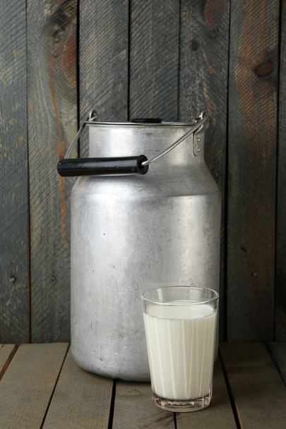 Retro can for milk on color wooden background - Foto, imagen