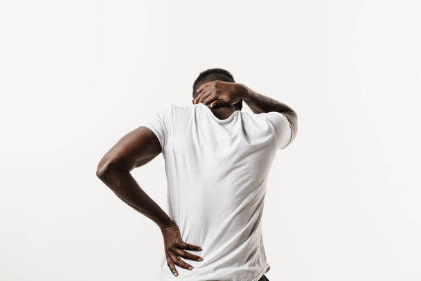 Rachiocampsis bachache und Nackenschmerzen eines afrikanisch-amerikanischen Mannes auf weißem Hintergrund. Skoliose ist eine seitliche Krümmung der Wirbelsäule. Rheuma und Arthritis - Foto, Bild