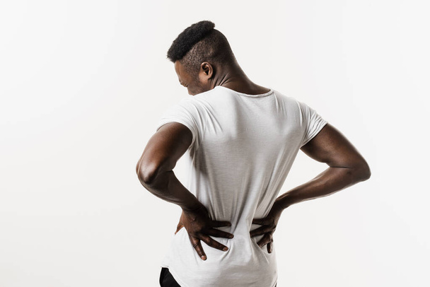 Hombre afroamericano siente dolor de espalda dolor de columna debido a la pielonefritis de ITU en el fondo blanco. Infección renal pielonefritis infección del tracto urinario - Foto, imagen