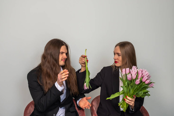 Женщина держит букет розовых тюльпанов и показывает один тули - Фото, изображение