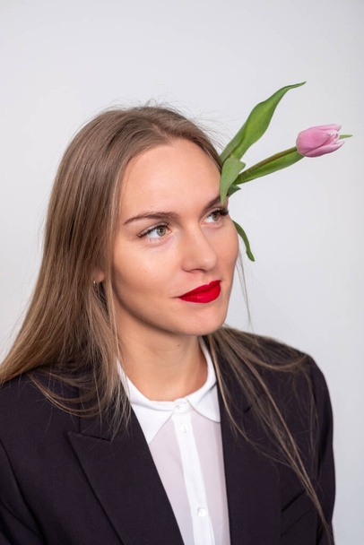 Krásná žena s růžovým tulipánem za uchem. Žena na sobě  - Fotografie, Obrázek