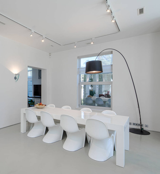 Interior moderno de la casa privada de lujo. Amplio salón con mesa y sillas. Paredes blancas. - Foto, Imagen