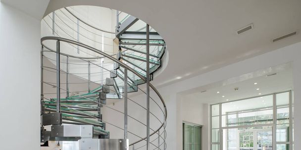 Modern interior of luxury private house. Spiral staircase made of glass and metal. - Photo, Image