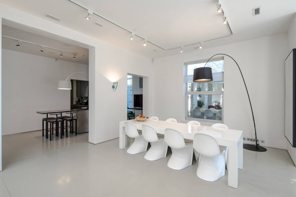 Moderní interiér luxusního soukromého domu. Prostorný obývací pokoj s jídelním stolem a židlemi. Bílé stěny. - Fotografie, Obrázek