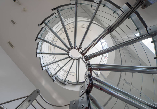 Modern interior of luxury private house. Spiral staircase made of glass and metal. View from below. - Photo, Image