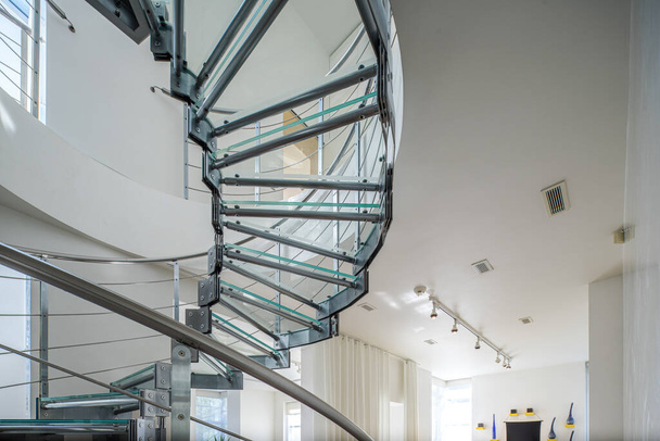 Interior moderno de la casa privada de lujo. Primer plano de escalera de caracol de vidrio y metal. Paredes blancas. - Foto, imagen