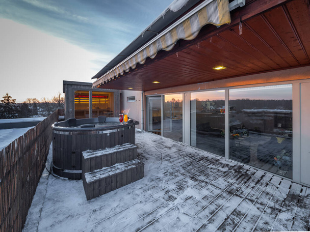 Open terras met warm buiten houten bad in de winter. Luxe privé huis. Modern huisje. - Foto, afbeelding