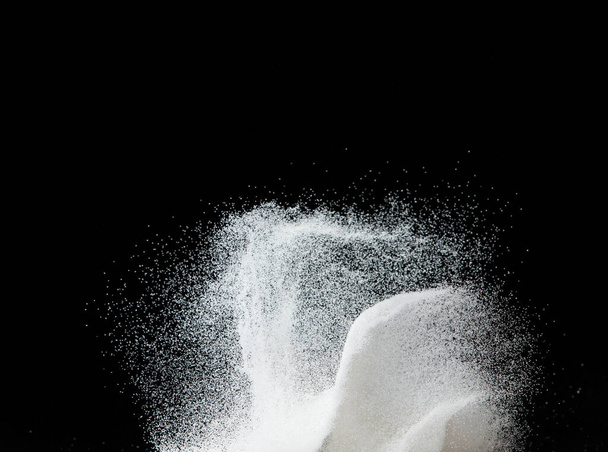 Εκατομμύρια άσπρη άμμο έκρηξη, Φωτογραφία από πτώση κάτω χιόνι ντους, βαριά χιονοθύελλες πετούν. Παγωμένη βολή σε μαύρο φόντο απομονωμένη επικάλυψη. Μικροσκοπική λεπτή άμμος ως επιστήμη σωματιδίων - Φωτογραφία, εικόνα