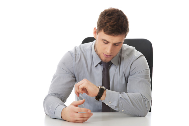 Businessman checking time on his watch. - Foto, afbeelding