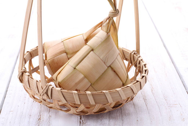 Ketupat (en indonesio y malayo), kupat (en javanés y sundanés) o tipat (en balinés) es un tipo de albóndigas hechas de arroz envasadas dentro de un contenedor en forma de diamante de una bolsa de hojas de palma tejida, originarias de Indonesia.. - Foto, Imagen