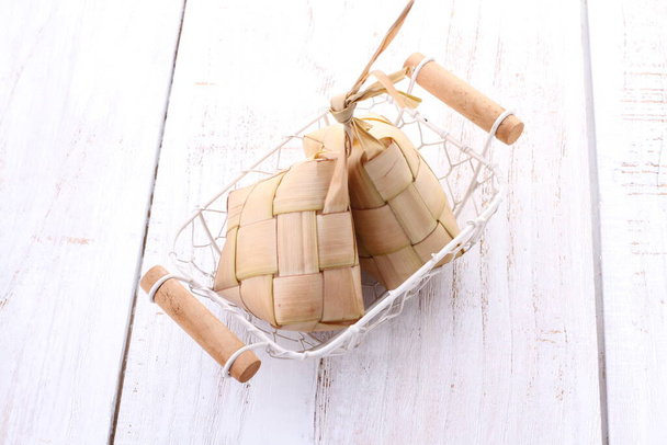 Ketupat (en indonesio y malayo), kupat (en javanés y sundanés) o tipat (en balinés) es un tipo de albóndigas hechas de arroz envasadas dentro de un contenedor en forma de diamante de una bolsa de hojas de palma tejida, originarias de Indonesia.. - Foto, imagen