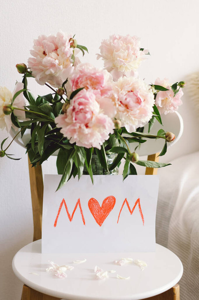 Happy Mothers Day. Fresh peonys and postcard for mom on white background. Stylish greeting card. Greeting card template with text - Фото, изображение