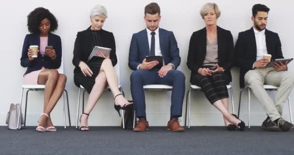 Vonal, interjú és tech egy csoport ember használ wifi a váróteremben a HR interjú a foglalkoztatás. Globális, változatos és a személyzet egy sorban toborzás tabletta és okostelefon. - Felvétel, videó