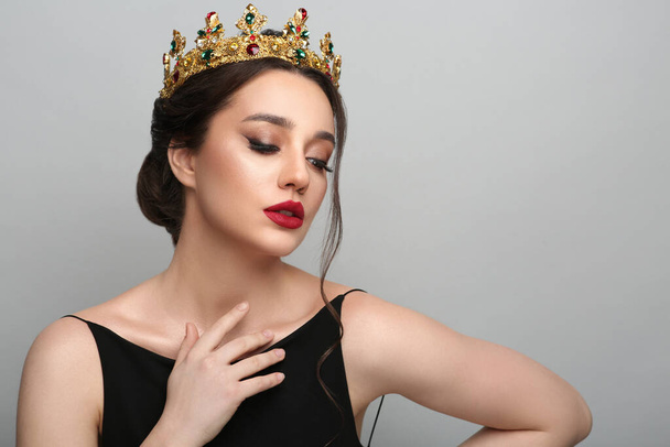 Beautiful young woman wearing luxurious crown on light grey background, space for text - Fotoğraf, Görsel