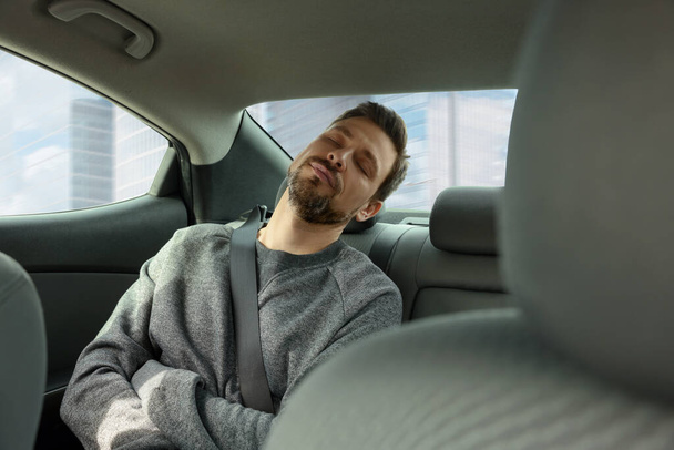 Fatigué bel homme dormant dans sa voiture moderne - Photo, image