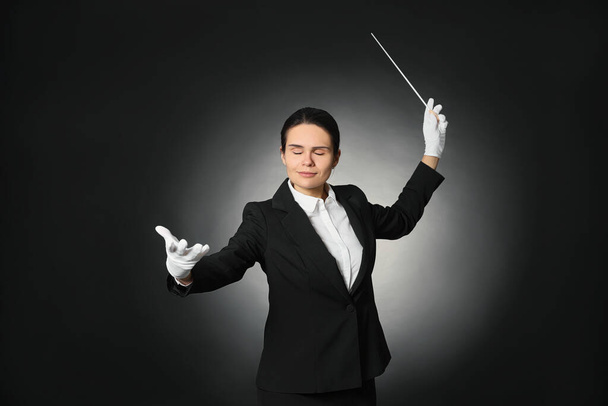 Professional conductor with baton on black background - Fotografie, Obrázek