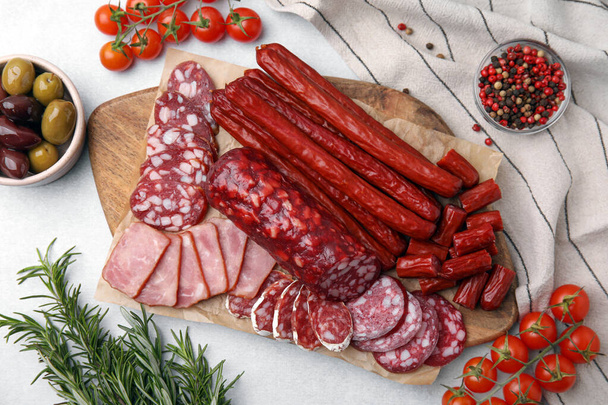 Flat lay composition with different types of delicious sausages and ingredients on light grey table - Photo, Image