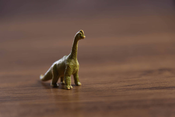 Toy dinosaurs on wooden surface. Toys. Dinosaurs Park. Miniatures and collections. Gifts for children. Adventure and fun. - Fotó, kép