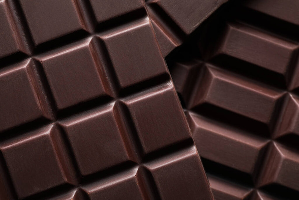 Many delicious dark chocolate bars as background, top view - Fotó, kép