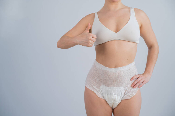 Woman in adult diapers showing thumbs up. Urinary incontinence problem - Photo, image