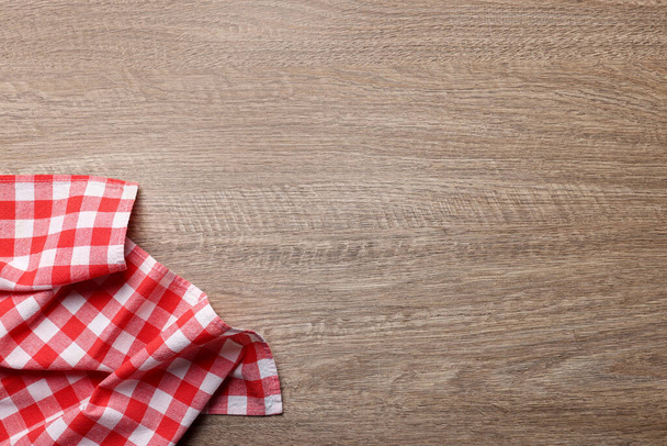 Checkered tablecloth on wooden table, top view. Space for text - Foto, afbeelding