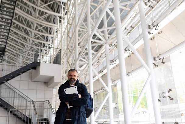 muotokuva eurooppalaisesta liikemiehestä, jolla on paperit käsissään rakennuksen aulassa. - Valokuva, kuva